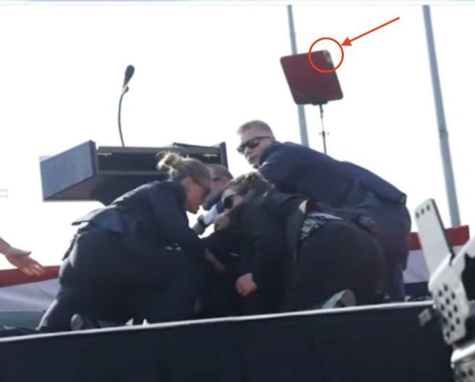Flexxdd's tweet photo. @BlowoutBiden @SlowBiden420 @nickinlasvegas @zekisezgin @YourAnonNews Slug hit teleprompter, causing glass to hit Donald’s ear. Slug then continued to the poor guy in the stands and took him out. Whats so fucking hard about this? https://t.co/oKpncirj8J