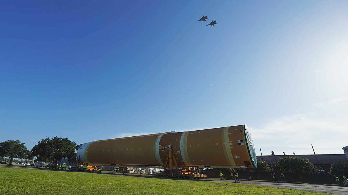 NASA_SLS's tweet photo. 🚀Rolling out!

The SLS core stage for #Artemis II is on the move at NASA's Michoud Assembly Facility heading toward @NASA's Pegasus barge.

After opening remarks from #NASA leadership, we marked this momentous occasion with an #AAFlyover, live music, and an employee event! 📸 https://t.co/f8iMonqph4