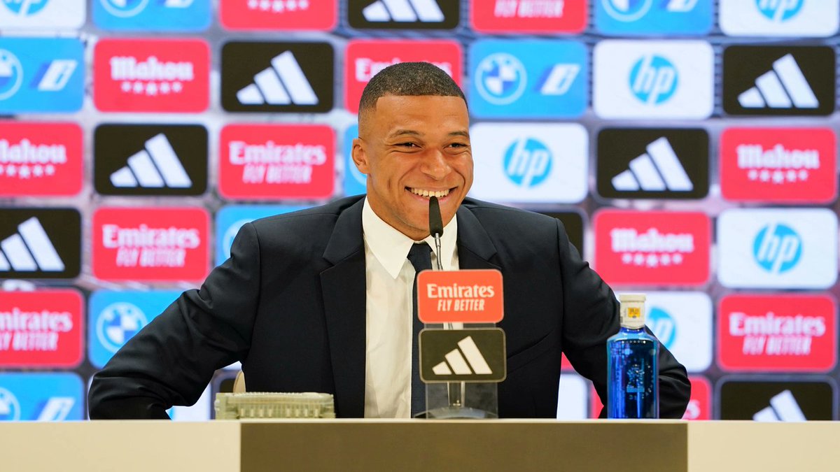SeputarMadrid's tweet photo. 🚨🎙️ | Transkrip konferensi pers pertama @KMbappe sebagai pemain baru Real Madrid, Selasa, 16 Juli 2024.

Setelah diperkenalkan sebagai pemain Real Madrid, Kylian Mbappé berbicara kepada media di ruang pers stadion Santiago Bernabéu.

Didampingi oleh Emilio Butragueño, Direktur Hubungan Institusional klub, penyerang baru Real Madrid ini datang ke ruang pers dengan membawa model kecil stadion kita dan mengatakan: “Ini adalah satu hadiah yang diberikan oleh keluarga saya saat saya berumur 8 tahun dan saya berjanji akan mengembalikannya. Ini adalah satu penghargaan bagi keluarga saya”. 

🗣️ Mbappé: “Sebuah kehormatan dan keistimewaan untuk menjadi pemain Real Madrid. Ini adalah satu hari yang fantastis. Saya mengharapkan satu hari yang luar biasa, tetapi ternyata jauh lebih baik dari yang saya harapkan. Terima kasih kepada Real Madrid dan semua madridista.”

“Masa lalu telah berlalu dan saya ingin menikmati masa kini. Saya ingin menikmati setiap detik dari hari ini karena ini adalah hari yang bersejarah dan saya ingin menceritakannya kepada anak cucu saya kelak.”

🗣️ Mbappé mengenai takdir yang membawanya menjadi pemain Real Madrid: “Saya merasa sangat terhormat bisa mengatakan bahwa saya adalah seorang pemain Real Madrid. Ini adalah mimpi saya sebagai seorang anak dan saya telah menunggu lama untuk momen ini. Sekarang telah menjadi kenyataan.”

“Anda tidak bisa membayar untuk sebuah mimpi. Ini merupakan satu kepuasan yang luar biasa bagi saya dan keluarga saya. Mereka tahu semua upaya yang harus saya lakukan untuk sampai ke sini, banyak tahapan.”

“Sekarang saya hanya ingin memikirkan saat ini, saya seorang anak yang sangat bahagia dan saya tidak sabar untuk bertemu dengan pelatih dan rekan-rekan setim untuk memainkan partai pertama saya.”

🗣️ Mbappé mengenai kapan ia memutuskan untuk bergabung dengan Real Madrid: “Sejak saya masih kecil. Pertama-tama, itu adalah sebuah mimpi dan kemudian sebuah tujuan, karena ketika Anda menjadi seorang profesional, Anda tahu bahwa Anda sudah dekat, namun saya tahu bahwa ini adalah takdir saya untuk bermain di sini.”

“Sekarang saya beruntung hari ini telah tiba. Saya sangat senang dan saya ingin menikmatinya.”

🗣️ Mbappé mengenai tujuannya untuk bergabung dengan Real Madrid: “Saya datang ke klub terbaik di dunia dan terbesar dalam sejarah dengan kerendahan hati dan ambisi. Ini adalah nilai-nilai klub: kerendahan hati, ambisi dan kemenangan. Prioritasnya adalah beradaptasi dengan baik bersama tim.”

“Ketika hal itu terjadi, segalanya akan menjadi lebih mudah. Saya ingin beradaptasi secepat mungkin.”

“Memang benar bahwa saya hampir menandatangani kontrak dua atau tiga tahun yang lalu, namun itu adalah bagian dari kehidupan seorang pesepak bola. Masa lalu sudah berlalu dan saya hanya memikirkan masa kini. Hari ini adalah hari yang akan menandai seluruh hidup saya.”

🗣️ Mbappé mengenai posisi favoritnya di lapangan: “Saya akan bermain di mana pun pelatih ingin saya bermain. Saya bisa bermain di tiga posisi depan. Saya pernah melakukannya bersama Paris, tim nasional dan Monaco. Yang paling penting adalah untuk tetap bugar secara fisik.”

“Saya ingin berada di lapangan, tetapi di mana saya bermain bukanlah sebuah perdebatan bagi saya. Itu tidak penting bagi saya.”

🗣️ Mbappé mengenai bagaimana ia menghadapi hari perkenalannya di Real Madrid hari ini: “Saya memiliki banyak tekanan pagi ini ketika saya bangun. Saya pikir saya harus menikmati setiap detiknya, jika rasa gugup tidak menghalangi saya untuk menikmati hari ini.”

“Semangat dan cinta yang ditunjukkan oleh para penggemar kepada saya sungguh luar biasa. Saya merasa seperti seorang pemain yang diadopsi dalam keluarga ini dan saya sudah merasakan hubungan itu dengan mereka.”

🗣️ Mbappé mengenai perasaannya untuk segera bergabung dengan tim: “Saya berbicara dengan pelatih pagi ini, tetapi tidak mengenai hal-hal taktis. Kami hanya bercanda. Saya tidak sabar untuk bermain dengan semua orang. Vini, Bellingham... Mereka semua adalah para pemain hebat. Pagi ini saya telah bertemu dengan beberapa rekan setim saya di Valdebebas.”

🗣️ Mbappé mengenai kenangan pertamanya sebagai madridista: “Zidane. Bagi orang Prancis dia adalah orang yang sangat penting dan kami mengikuti semua pertandingannya di sini. Kemudian idola saya adalah Cristiano dan saya menonton semua pertandingannya. Kemudian saya tidak bisa menontonnya dengan sering karena saya harus bermain sebagai profesional.”

🗣️ Mbappé mengenai apa yang dapat ia berikan kepada tim: “Ini adalah tim yang selalu menang. Mereka selalu menang, dan itulah mengapa mereka adalah tim terbaik di dunia. Yang ingin saya lakukan adalah memberikan kontribusi. Saya sangat senang dan saya tidak sabar untuk melakukan semua yang mereka minta dan berlatih.”

🗣️ Mbappé mengenai apakah dia berpikir bahwa impiannya tidak akan terwujud untuk bermain di Real Madrid: “Saya yakin bahwa waktu saya akan tiba. Madrid adalah satu-satunya pilihan. Saya mendapatkan tawaran dari klub-klub lain, tetapi saya selalu mengatakan bahwa ketika saya meninggalkan Paris saya akan pergi ke Madrid. Di kepala saya sudah jelas bahwa klub saya berikutnya adalah Real Madrid. Tanpa keraguan.”

🗣️ Mbappé mengenai cedera hidungnya: “Kami sedang melakukan kontak dengan staf medis klub. Mereka yang akan memberikan informasi lebih lanjut kepada saya dalam beberapa hari kedepan, ketika mereka telah mendapatkan hasilnya.”

“Ketika saya kembali dari liburan, mereka akan memberitahukan kepada saya bagaimana saya dapat mempersiapkan diri untuk membantu tim secepat mungkin.”

“Saya berharap dapat bermain di UEFA Super Cup, namun itu tergantung pada kesiapan saya. Saya akan bekerja untuk itu. Sebuah gelar di partai pertama saya akan menjadi satu hal yang unik.”

🗣️ Mbappé mengenai Florentino Pérez: “Sejak hari pertama dia mempercayai saya. Dia membantu saya dan keluarga saya dan selalu memberikan banyak kasih sayang. Hal ini sangat penting karena sebelum menjadi seorang pemain, saya adalah seorang pria.”

“Merasa bahwa bos ada bersama Anda adalah hal yang sangat penting. Semua orang yang bekerja di klub ini telah melakukan pekerjaan yang sempurna karena saya berada di sini hari ini.”

🗣️ Mbappé mengenai apakah ada rekan setimnya yang mendesaknya untuk datang ke sini: “Mereka yang berkebangsaan Prancis. Juga Vini, yang mengirimi saya pesan dan mengatakan kepada saya untuk datang dan bermain bersama di lini depan, serta para pemain lain yang pernah saya hadapi ketika saya di Paris..”

🗣️ Mbappé mengenai persiapannya untuk mengarungi musim 24/25 bersama Real Madrid: “Kami berbicara pagi ini dengan Pintus dan orang-orang di sekitar saya untuk mempersiapkan program yang baik karena ini akan jadi musim yang sangat panjang.”

“Kami akan memainkan tujuh kompetisi. Kompetisi berikutnya juga akan berlangsung panjang dan kami membutuhkan persiapan khusus untuk menghadapinya.”

“Saya ingin mempersiapkan diri dengan cara yang terbaik untuk bisa memenangkan gelar di sini.”

🗣️ Pesan Mbappé untuk para pendukung: “Ini adalah bagian dari sepak bola. Orang-orang memberikan banyak cinta kepada Anda, tetapi ada kalanya mereka lebih marah kepada Anda.”

“Sungguh luar biasa kasih sayang dan cinta yang diberikan oleh para madridista kepada saya karena saya bukan siapa-siapa di Madrid.”

“Saya ingin memberikan hidup saya untuk kostum ini dan klub ini. Kenyataan bahwa ada orang-orang yang telah percaya kepada saya sejak hari pertama berarti bahwa saya harus melakukan sesuatu dengan benar.”

🗣️ Mbappé mengenai Bernabéu dan hal-hal magis yang terjadi di dalamnya: “Ketika Anda datang ke sini, Anda tahu bahwa Anda akan bermain melawan klub terbaik di dunia. Ketika saya datang ke sini bersama PSG, saya datang untuk bermain bagi PSG. Sama seperti sekarang ini saya akan bermain bagi Real Madrid.”

🗣️ Mbappé mengenai sejarah besar Real Madrid: “Saya datang ke sebuah klub bersejarah. Warisan sejarahnya sangat membebani pundak Anda ketika Anda mengenakan seragam ini, tetapi saya menganggapnya sebagai sebuah kehormatan.”

“Saya sudah cukup beruntung untuk bermain di klub-klub besar sebelumnya. Di Monaco mereka melatih para pemain dengan sangat baik, PSG dan sekarang Real Madrid.”

“Sebuah kebanggaan yang luar biasa bisa berada di sini dan saya berharap bisa menjadi bagian dari sejarah klub terbesar di dunia ini.”

🗣️ Mbappé mengenai bermain dengan Vini Jr. dan Rodrygo: “Vini Jr. adalah pemain yang unik, saya sangat senang bermain bersamanya, juga dengan Rodrygo, dan juga dengan semua anggota tim.”

“Saya rasa saya tidak akan mengalami masalah bermain bersama Vini Jr. Beberapa musim terakhirnya sangat sempurna. Sekarang saya datang dan saya harus beradaptasi dengan tim untuk membantu Vinicius, Rodrygo dan semua pemain untuk meraih kemenangan.”

🗣️ Mbappé mengenai gelar juara: “Tidak ada tempat yang lebih baik daripada di sini untuk memenangkan gelar. Prioritas saya sekarang adalah beradaptasi dengan baik bersama tim, itulah kuncinya.”

“Jika saya bermain baik sebagai sebuah tim, hal-hal lainnya akan datang.”

“Saya memiliki target seperti memenangkan Liga Champions, LaLiga, Copa del Rey dan yang lainnya. Akan tetapi itu semua adalah tujuan jangka panjang. Yang pertama adalah berlatih dan beradaptasi dengan baik.”

🗣️ Mbappé mengenai mengapa dia tidak datang ke Real Madrid lebih awal: “Banyak hal yang bisa terjadi dalam sepak bola. Yang bisa saya katakan adalah bahwa saya sangat senang berada di sini dan akhirnya menjadi pemain di klub terbaik di dunia.”

🗣️ Mbappé mengenai apakah ia ingin mengenakan nomor punggung 10 Real Madrid: “Kami memiliki nomor punggung 10, itu adalah Luka Modrić. Ia adalah salah satu pemain terbaik di dunia, ia adalah peraih Ballon d'Or, saya senang bisa berdekatan dengannya di ruang ganti, sebuah kebanggaan.”

“Nomor itu tidak penting bagi saya. Saya tidak melihat apa yang ada di belakang saya, hanya apa yang ada di depan saya, yaitu gawang dan gol.”

“Nomor 9 sangat penting di Real Madrid. Sebuah kehormatan untuk menjadi bagian dari tim ini dengan nomor punggung itu.”

🗣️ Mbappé mengenai kunjungannya ke Valdebebas pada usia 14 tahun: “Saya datang pada tahun 2012 bersama Zizou. Itu adalah satu hal yang gila, satu mimpi. Ketika saya masih berusia 13 atau 14 tahun diundang oleh Zidane itu sangat luar biasa.”

“Saya sangat bersemangat dan itu adalah momen dalam hidup saya ketika saya menyaksikan semua pertandingan. Saya datang bersama keluarga saya dengan berpikir untuk menjadi pemain Real Madrid suatu hari nanti.”

“Banyak anak-anak yang meninggalkan stadion dengan membawa mimpi dan saya ingin mengatakan kepada mereka bahwa dengan semangat, apapun bisa terjadi.”

🗣️ Mbappé mengenai tingkat kemampuan bahasa Spanyolnya: “Saya bukan yang terbaik di sekolah, tetapi dalam bahasa Spanyol saya berada dalam level 100 persen karena saya memiliki mimpi untuk bermain di sini.”

“Bahasa Spanyol saya sudah bagus, tetapi saya bisa meningkatkan kosakata kehidupan. Berbicara dalam bahasa Spanyol setiap hari akan membantu saya berkembang.”

“Saya juga memiliki pelatih yang bisa berbahasa Spanyol seperti Pochettino atau Luis Enrique.”

🗣️ Mbappé mengenai hari perkenalannya sebagai pemain Real Madrid: “Saya telah membayangkan momen ini berkali-kali... Namun, tahap ini sungguh luar biasa. Saya tidak menyangka akan mendapatkan begitu banyak kasih sayang dari semua madridista.”

🗣️ Mbappé mengenai apa yang dikatakan oleh rekan-rekan setim barunya: “Mereka mengatakan kepada saya bahwa tidak ada klub lain yang seperti Real Madrid.”

“Itu berarti bahwa ketika Anda datang kesini, Anda akan mendapatkan satu pengalaman yang unik yang tidak bisa anda dapatkan di tempat lain.”

“Semua orang yang bekerja di sini memiliki semangat untuk klub ini dan hal itu ditularkan. Saya melihat hal itu ketika saya datang ke sini pada tahun 2012.”

🗣️ Mbappé mengenai bagaimana dia mengetahui tentang perekrutannya ke Madrid dan apakah dia sudah bergabung dengan grup whatsApp Real Madrid: “Saya belum masuk dalam grup whatsApp. Hari ini saya sudah dapat mengatakan bahwa saya adalah seorang pemain Real Madrid.”

“Saat itu jam 11.00 dengan presiden. Anda bisa melihat videonya jika anda menginginkannya (tertawa).”

🗣️ Mbappé mengenai rangkuman dari hari yang telah dilaluinya: “Saya tidur selama satu setengah jam dan terbangun dengan perasaan tegang karena menikmati setiap detik hari ini.”

“Sangat penting untuk memberi tahu diri saya sendiri tentang segala sesuatu karena saya tahu itu akan bertahan seumur hidup.”

“Ini lebih dari yang saya harapkan. Ini adalah hari yang unik. Sangat berarti bisa berada di sini dan sangat luar biasa melihat stadion ini dengan semua madridista. Saya tidak memiliki kata-kata yang cukup untuk mengungkapkan apa yang ada di hati saya.”

“Saya ingin berbagi hal ini dengan keluarga saya dan anak-anak di yayasan saya. Saya ingin mereka merasakan pengalaman ini bersama saya.”

“Saya tahu apa artinya memiliki satu mimpi dan saya ingin membaginya dengan orang-orang saya, dengan para madridista, dengan anak-anak dan dengan semua orang yang memiliki mimpi seperti saya.”

🗣️ Mbappé mengenai apakah dia akan ikut dalam tur ke Amerika Serikat: “Jika klub menginginkan saya pergi maka saya akan pergi dan jika mereka tidak menginginkan saya pergi maka saya tidak akan pergi. Saya akan melakukan apa yang diinginkan oleh klub.”

🗣️ Mbappé mengenai tujuannya di Real Madrid: “Tujuan saya tidak berbeda dengan tujuan klub - memenangkan titel. Saya harus beradaptasi terlebih dahulu. Klub ini telah memenangkan berbagai gelar sebelumnya dan akan memenangkannya setelah saya.”

“Saya ingin memenangkan gelar bersama klub ini dan dari pengalaman saya, saya tahu bahwa merupakan sebuah kesalahan jika saya menetapkan target gol untuk diri saya sendiri.”

“Saya bukan satu-satunya pemain yang bisa mencetak gol di tim ini.”

🗣️ Mbappé mengenai Endrick: “Saya tahu reputasinya dan itu sangat bagus. Saya belum sering melihatnya bermain, hanya bersama tim nasional Brasil. Jika ia bergabung dengan Real Madrid, saya yakin ia adalah seorang pemain berbakat.”

“Dia masih muda dan dia harus belajar banyak hal. Jika ia membutuhkan saran atau bantuan, ia akan mendapatkannya karena saya tahu apa artinya memulai karier di usia muda dan memiliki tekanan pada usia tersebut.”

“Saya yakin dia akan membantu tim dan mencetak gol.”

🗣️ Mbappé mengenai video masa lalunya ketika berada di di Madrid: “Saya melihat videonya di TV dan saya sangat gembira. Saya berpikir untuk menikmati waktu bersama orang-orang, keluarga saya dan semua madridista. Ini adalah satu hari yang sangat indah bagi saya, bagi keluarga saya dan saya berharap bagi semua madridista dan bagi klub”.