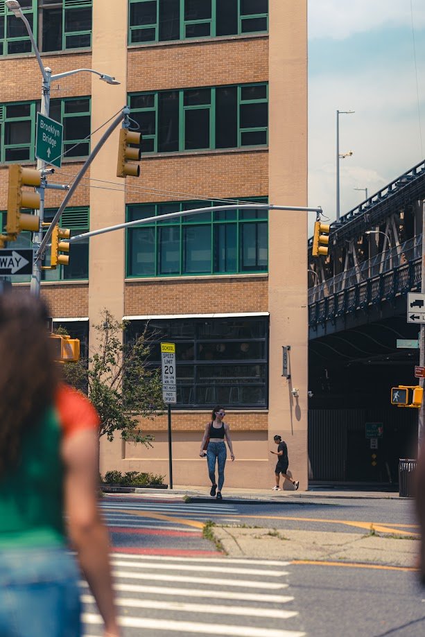 Layers with people.

Would have been cool to have the middle woman in the light as well, but I really wanted that guy placed there in the frame at the corner of the building.

The foreground colors grabbed the first attention for me and I follow the composition to the woman