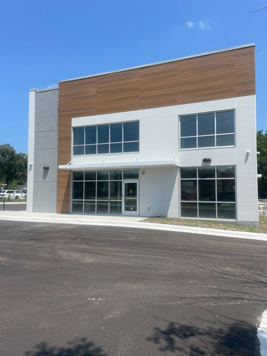 Brandon Abel, job superintendent, is keeping pace at the new Heartland Blue Stem Wellness Building which houses admin offices, conference &amp; therapy rooms. Shown are the exterior, front entry, conference room with a view of the grounds, and a bathroom. Work is moving along well.