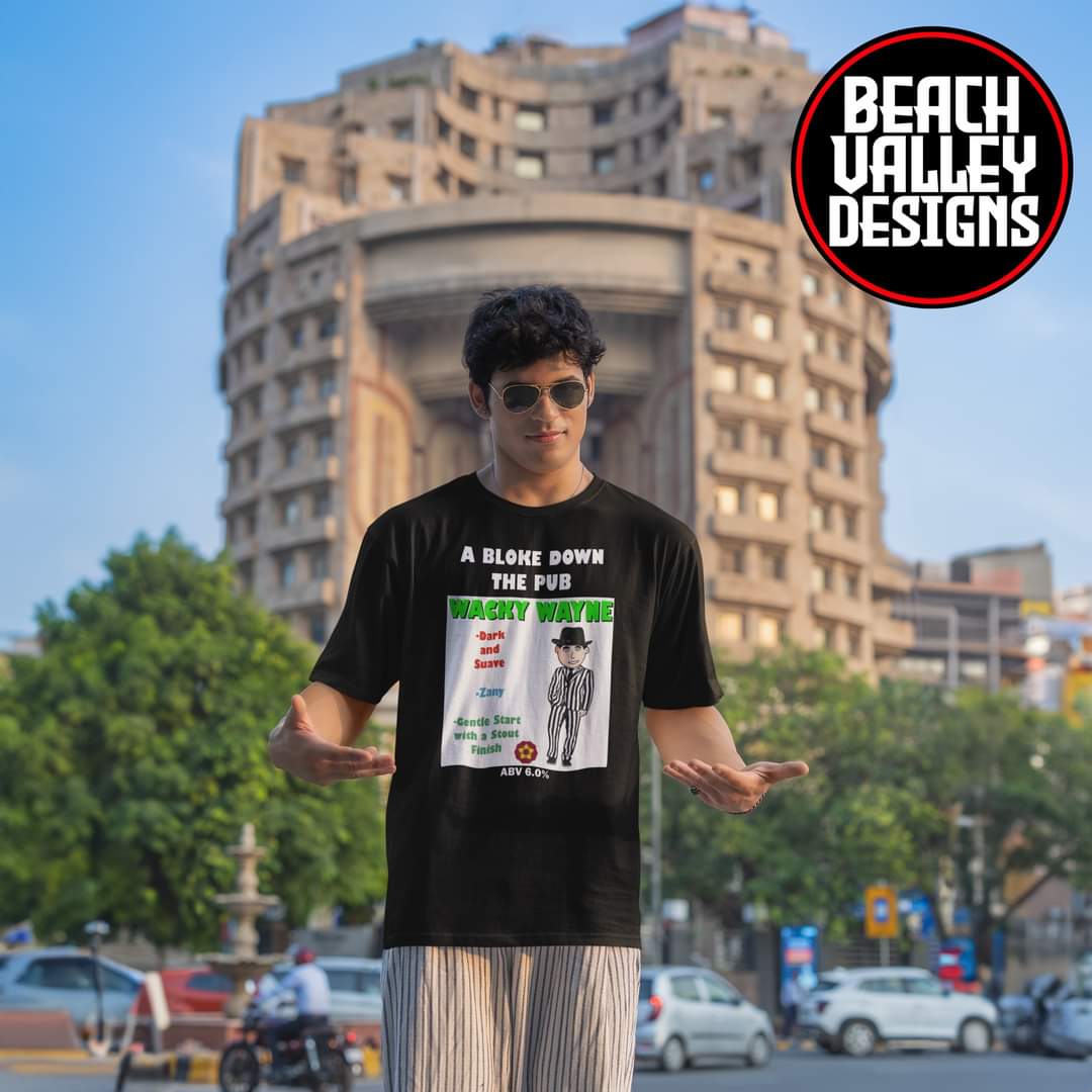 WACKY WAYNE man standing on a street, wearing sunglasses and and his favorite black T-shirt with a colorful design.

beachvalleydesigns.com/collections/a-…