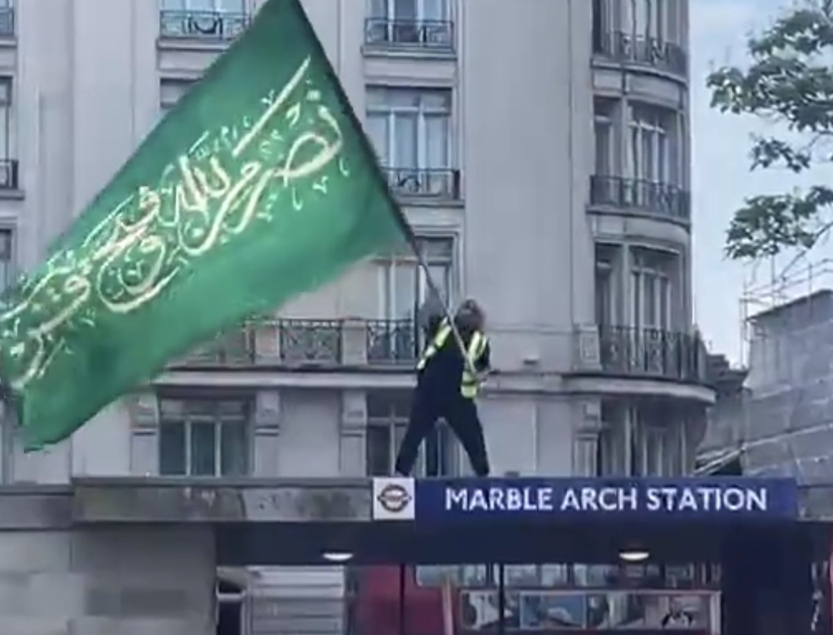 DaveAtherton20's tweet image. The words on the Jihad Muslim flag at Marble Arch, my Arabic speaking followers tell me, is a Quranic verse saying:

"Help from Allah for a victory to come soon"(61:13)"

It is a call to violence with strong anti-Semitic undertones. 

Cc @PatrickChristys @MarkJLittlewood @EssexPR…