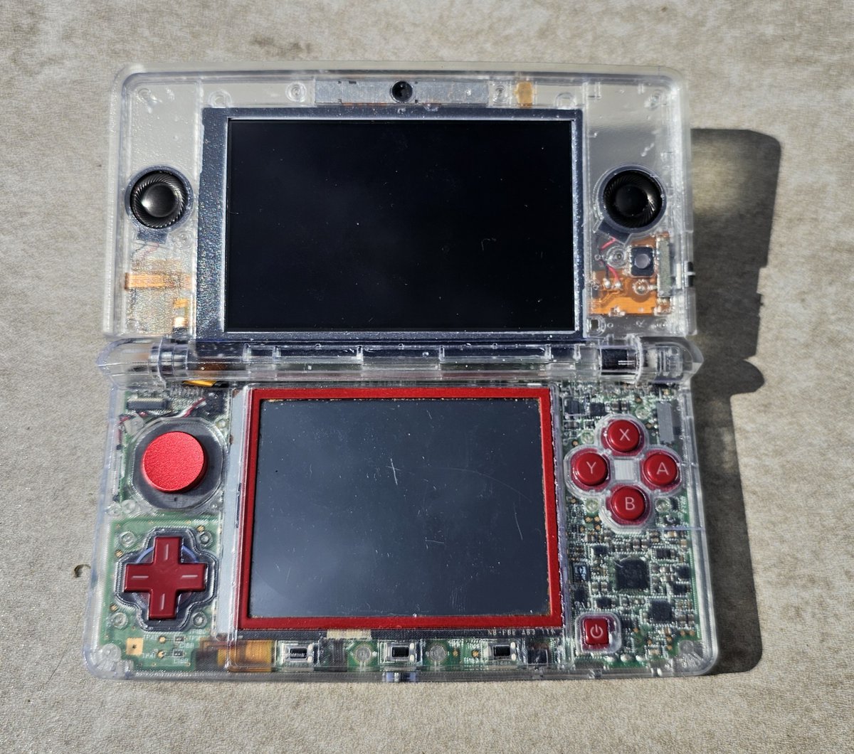 KampCreates's tweet photo. Transparent 3DS prototype?
Nah, this is just the 3D printed shell model that I've been working on. I used some junk parts to test fit, so this one doesn't work just yet, but I'm really excited to get it running.
Should I go with or without the black faceplate? https://t.co/CV1oqyukct