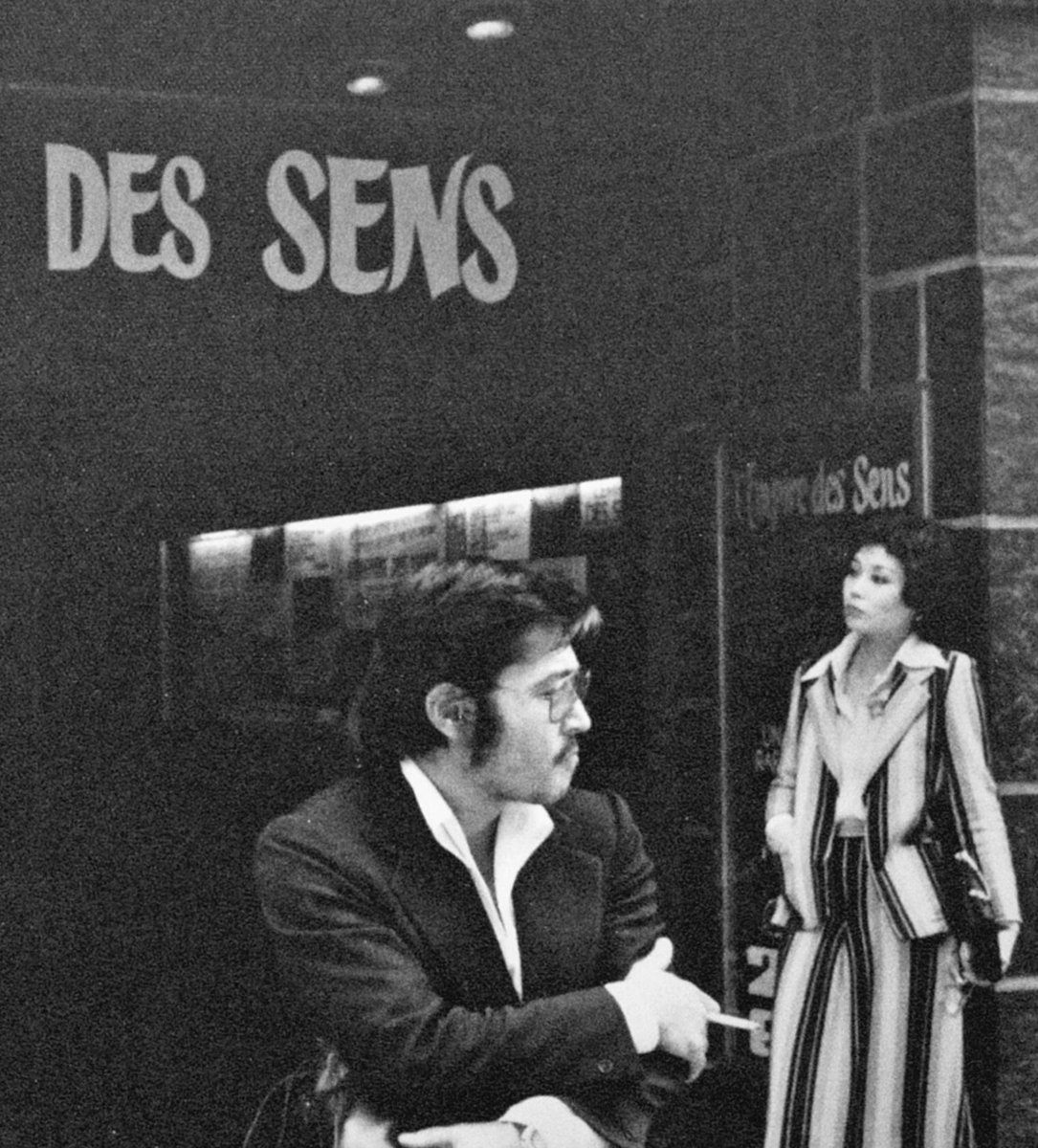 1976年､映画｢愛のコリーダ｣がパリの劇場で公開された時の様子を見に来た藤竜也と松田暎子｡阿部定事件とその性愛を題材に大島渚が映画化｡同年のカンヌ国際映画祭でも上映され､高い評価を受けた｡さて現地の人々は70年代のファッションを身に纏う2人が同作品の主演であることに気付いたのか？