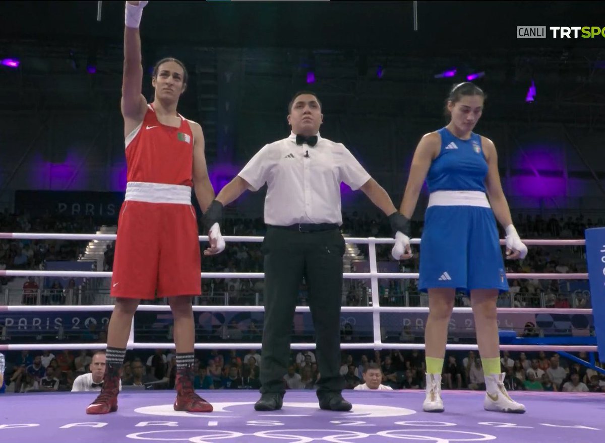 Cezayirli trans yani biyolojik olarak erkek. Kadınlar kategorisinde yarışıyor. Haksız rekabet. İrlandalı boksör biyolojik erkekle dövüşmeyi reddetti.

İtalyan kadın boksör yediği ilk yumruktan sonra protesto etmek için maçı bıraktı.

Busenaz transla dövüşme. Sen de çekil.