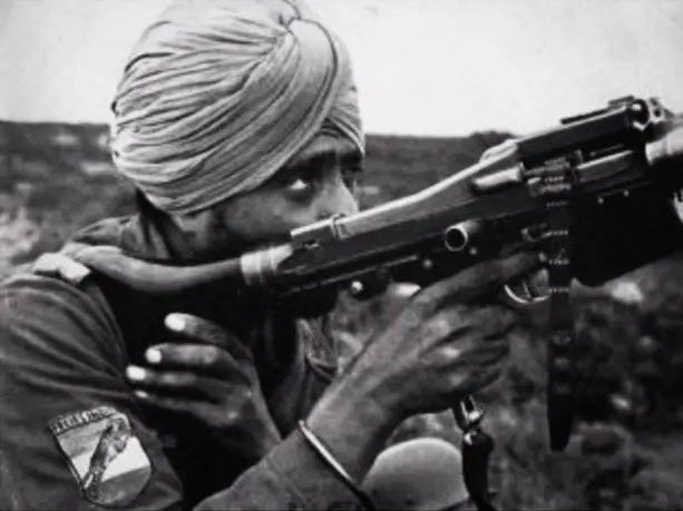 A Sikh Indian soldier of the Indian Legion (Tiger Legion) with a German MG 34 machine gun. Illustrated in IA and B. 

The other image is the actual photograph of the soldier based on whom this stamp was designed.