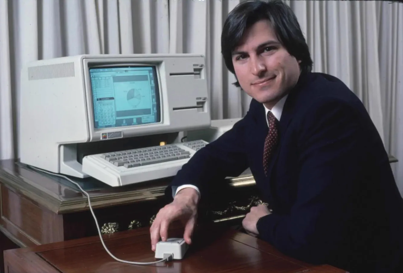 Steve Jobs sits beside the newly released Apple Lisa 