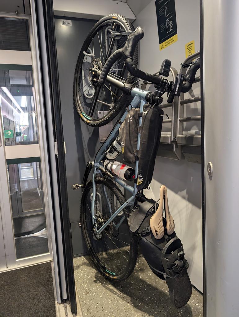 __jakemay's tweet image. This design of storing bikes on trains is so poor @GWRHelp. So much weight and pressure on one spoke and apparently there's room for a second bike here. Also completely inaccessible for anyone who can't lift their bike up like this