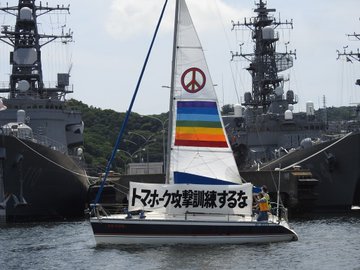 自衛隊と米軍のトマホークミサイル訓練に抗議するヨコスカ平和船団。軍艦に向かって「トマホーク攻撃訓練するな」の横断幕を掲げているヨット。
