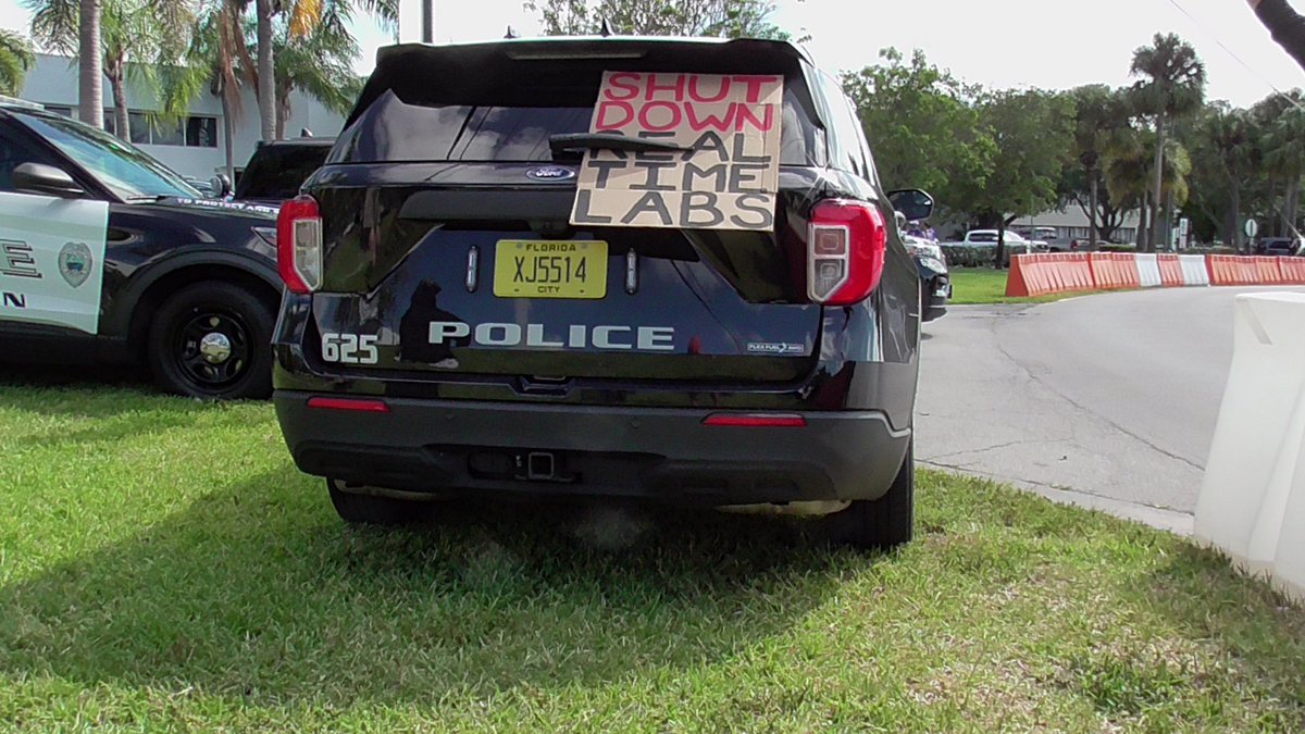 sdesfl's tweet photo. Alt text: 
Photo 1: “this is a genocide on the entire demography of Gaza” - Bisan Owda
Photo 2: end the genocide on cardboard 
Photo 3: cardboard that reads shut down real time labs stuck behind the back windshield wiper of a Boca PD police SUV
Photo 4: two ignore a yelling Zio https://t.co/3WVb6SuPbf