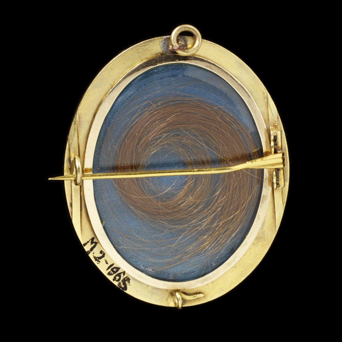 Brooch, gold plaques decorated with composition of a bird, a nest with eggs ( pearls), and forget-me-nots ( enamelled in blue). Fitted with a locket back which contains a lock of hair, possibly made by Harry Emanuel of London, 1855-73. Victoria &amp; Albert