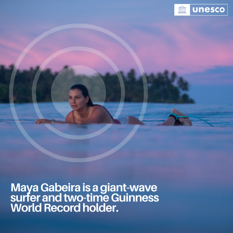 UNESCO's tweet photo. @UNESCO's Champion for the Ocean and Youth, @MayaGabeira, has not only conquered enormous waves but also set numerous world records, inspiring a new generation of surfers.

Maya continues to #ChangeTheGame! 🏄‍♀️