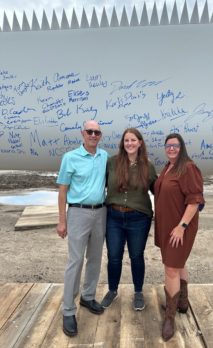 ParkerPoe's tweet photo. Parker Poe’s Henry Campen, retired of counsel, Merrick Parrott, and Katherine Ross, were thrilled to join nearly 300 people in Edenton this week for a turbine blade signing to celebrate construction of Timbermill Wind, a 189-megawatt utility-scale wind farm. @ApexCleanEnergy https://t.co/2tyfFzY6TP