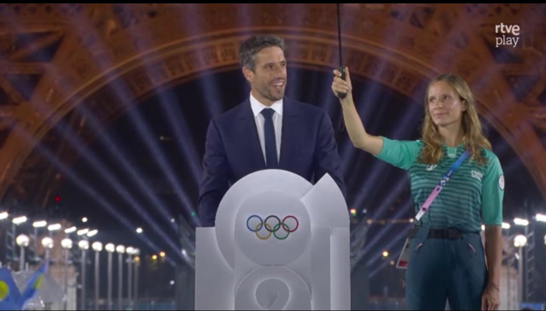 jdguardiola's tweet image. “No nos intimidamos ante unas gotas de lluvia”, dice el gachó mientras una mujer le sujeta un paraguas #CeremoniaDeApertura #salutparisrtve