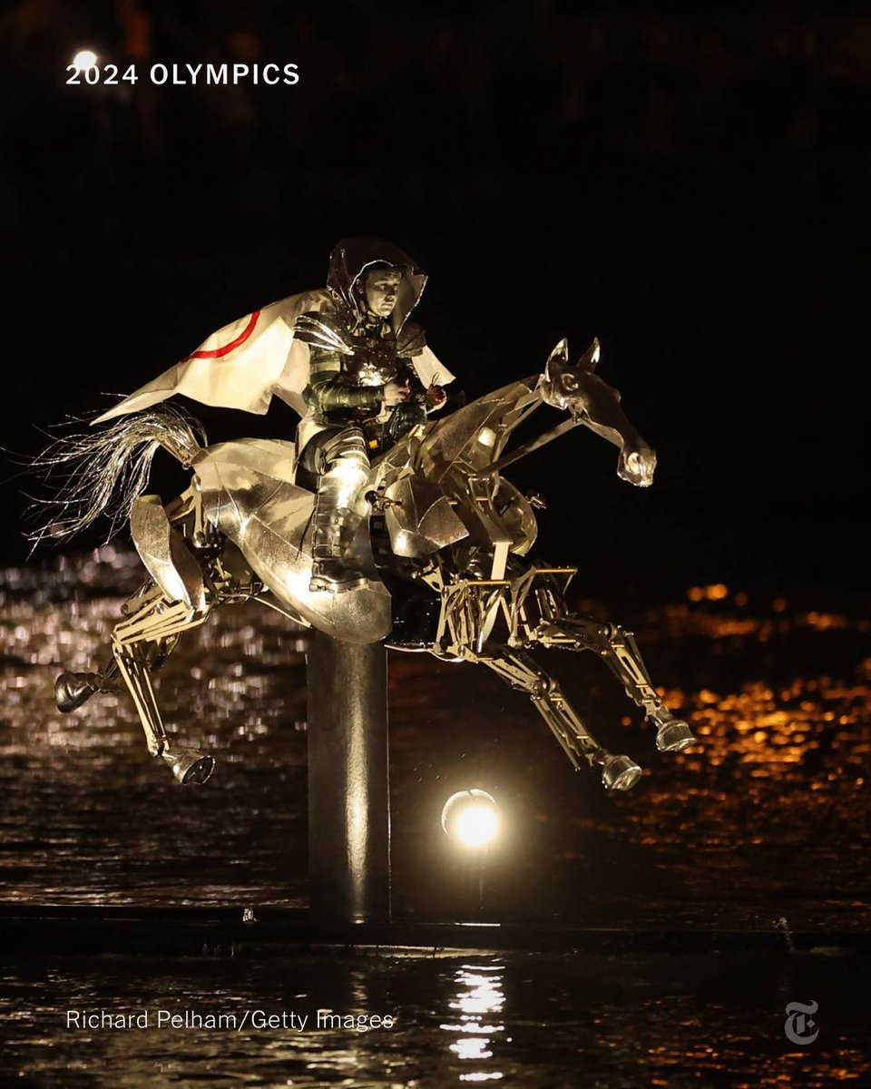 nytimes's tweet photo. "A Joan of Arc figure appears riding a mechanical silver horse 'galloping' down the Seine. Her armor is by a young French designer named Jeanne Friot," our fashion critic writes. Follow live updates from the Olympic opening ceremony. https://t.co/DKTAo97N0v https://t.co/dsNOzCef7C