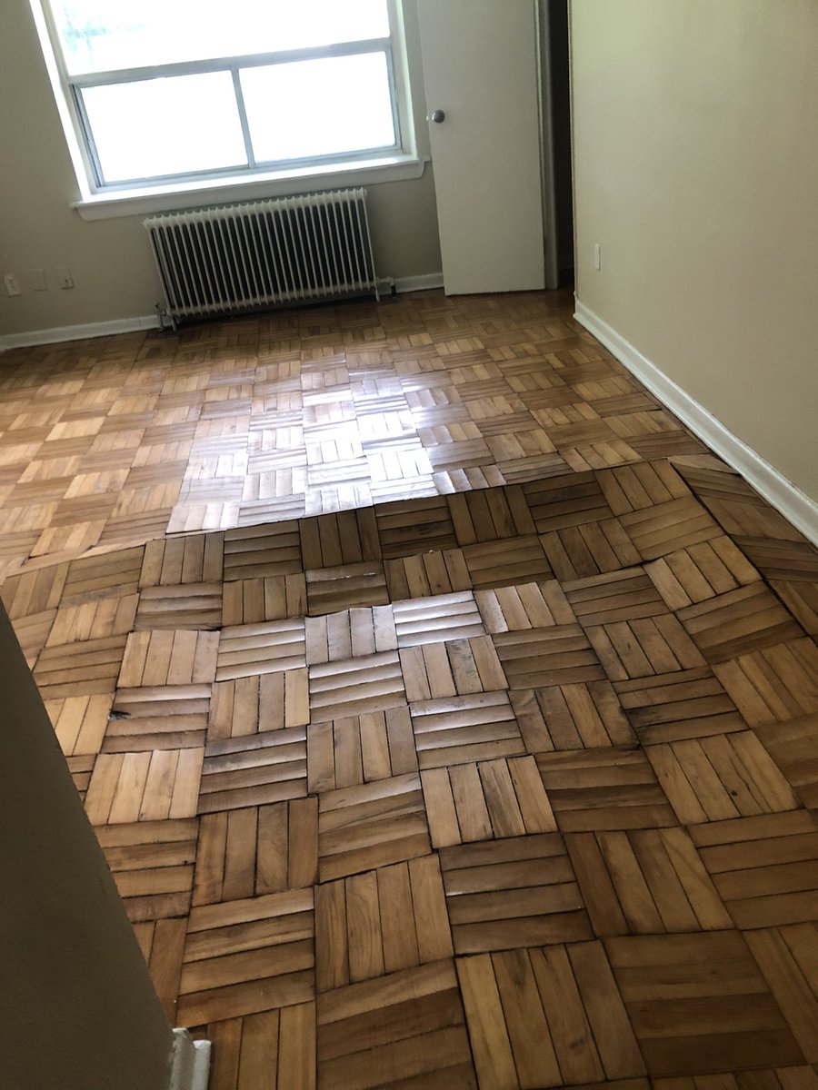 ID: A parquet floor that is extremely warped and buckled.