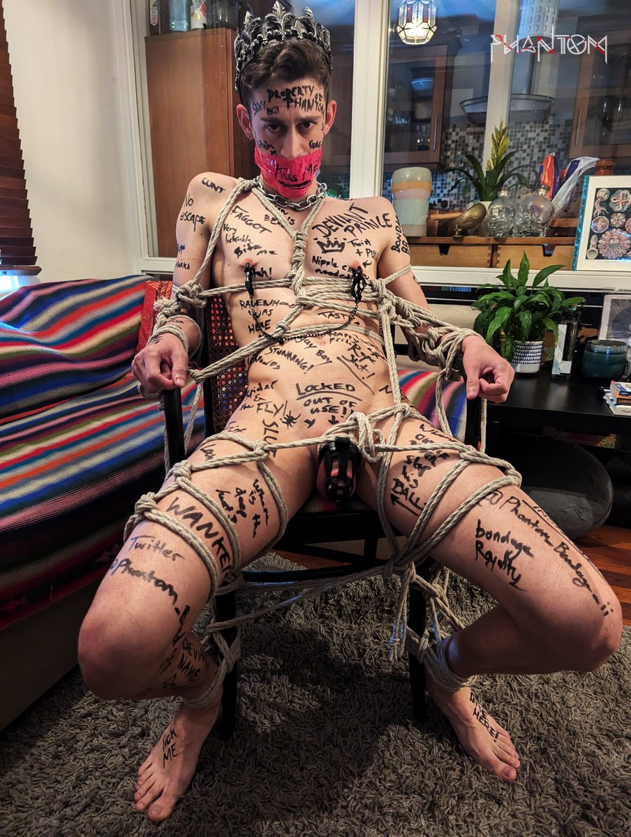 Phantom_Bondage's tweet photo. Chastity diary of @DeviantPrince 03:

As if being locked and horny wasn't humiliating enough...
We were about to do a shoot with our dear friend @sand_amst 
What the Prince didn't know was that I had an ace up my sleeve for this scene. After he was tied down to the chair fully naked and gagged tightly with pink tape, the crown and the cage being his only outfit.
I quietly revealed the pen marker that was in my pocket.
All he could do was roll his eyes and make a feeble protest moan from under the tape.

He might be royalty, but now he was 𝘔𝘺 𝘭𝘪𝘵𝘵𝘭𝘦 𝘉𝘪𝘵𝘤𝘩 💋