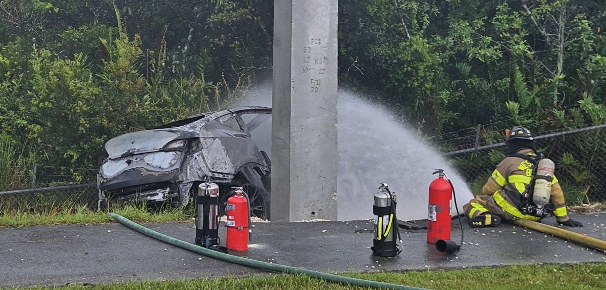 WestPalmPD's tweet photo. #TrafficAlert Eastbound Northlake Boulevard 2 lanes closed east of  Ibis @Publix, traffic being routed around one-car crash. Call came in at 4:31 p.m. @Tesla veered off road, hit fence, caught fire. @WPBfire putting out fire. Man driving and toddler rushed to @StMarysMC. https://t.co/O6YcPwDRUB