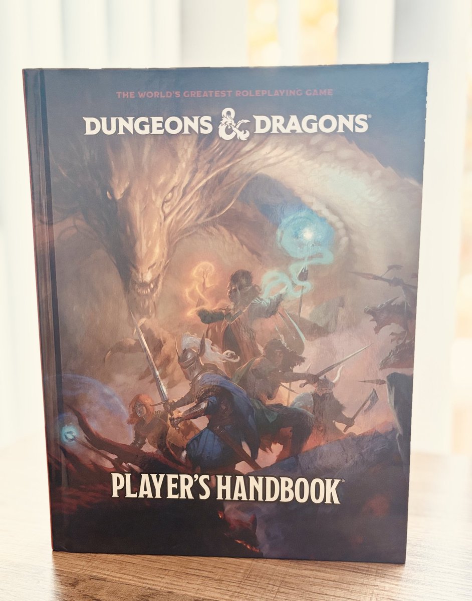 Talk about timing! Look what I received just before heading to #GenCon! Big thank you to <a href="/Wizards_DnD/">Dungeons & Dragons</a> for gifting me a copy of the new version of the #DnD players handbook 😁 Excited to dive into this soon! This cover art by <a href="/jacobsontyler/">Tyler Jacobson</a> is stunning!