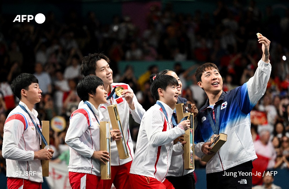 AFP's tweet photo. An uplifting moment at the #OlympicGames  as images of table tennis players from North Korea and South Korea taking a selfie together on the medal podium in Paris went viral in South Korea, hailed as a rare show of cross-border unity.
#AFPSports 
https://t.co/gRsAYN1VZ2 https://t.co/zjo7qHBfQa