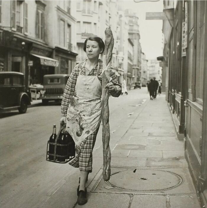 Una mujer francesa con su baguette y seis botellas de vino, París, Francia, 1945.