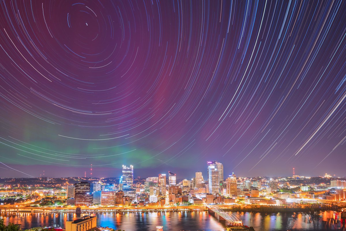 This is a composite image from today in #Pittsburgh, comprised of 1,064 images show the stars as they circle above the city behind the aurora borealis. I've captured star trail images before, but never like this with the Northern Lights. Still can't believe this happened again.