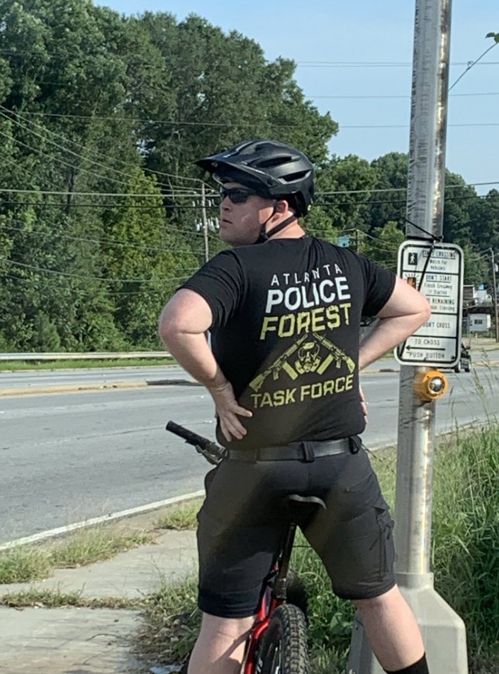 Spotted in the vicinity of the Weelaunee forest today: a man in a shirt reading "Police Forest Task Force" featuring rifles with extended clips and a gas mask. This is not the look of people who work for peace and safety; rather, they are at war with the community. #StopCopCity