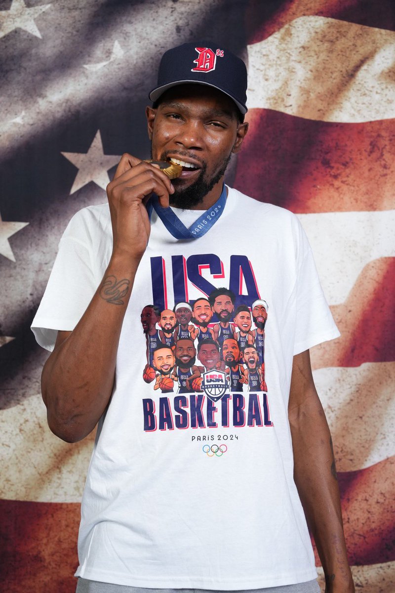 WorldWideWob's tweet photo. Wild story here re: the shirts Team USA Men’s Basketball wore during their🥇celebration.

Content creator (Joe Vadakkedam) claims it was his creation, and describes how it all went down.

Nike/Fanatics’ versions are not featured in the photo shoot.

🎬➡️https://t.co/TXterIl5hy https://t.co/pXefulautm