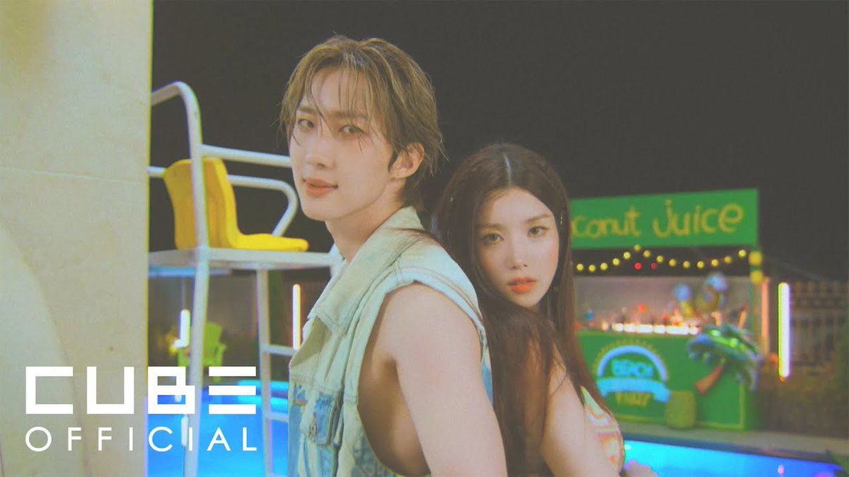 A promotional image shows a young man in a denim vest and a young woman with long dark hair posing back-to-back near a pool at night, with 'CUBE OFFICIAL' text and a 'Coconut Juice' stand in the background.