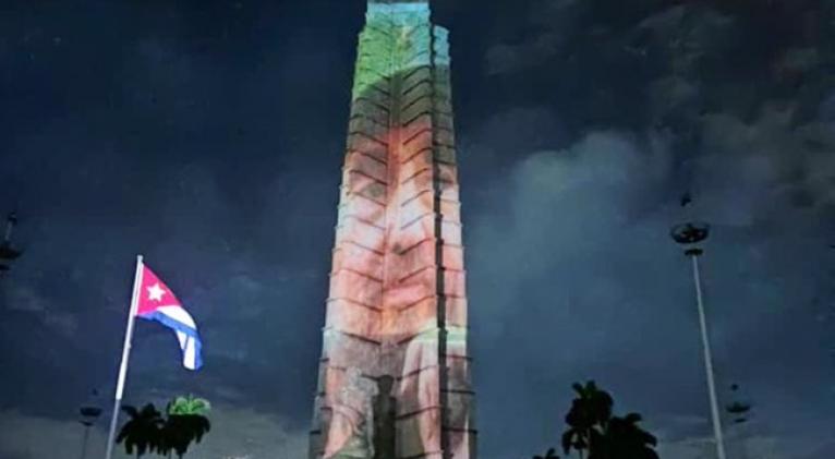 UJCdeCuba's tweet photo. En homenaje al aniversario 98 del natalicio del Líder Histórico de la  #Revolución🇨🇺, #FidelCastro, la emblemática Plaza de la Revolución José  Martí, se iluminó minutos antes de arribar a este 13 de agosto, con una proyección gigante de su rostro.
#FidelPorSiempre #UJCdeCuba https://t.co/yQ1cR5W5Ll