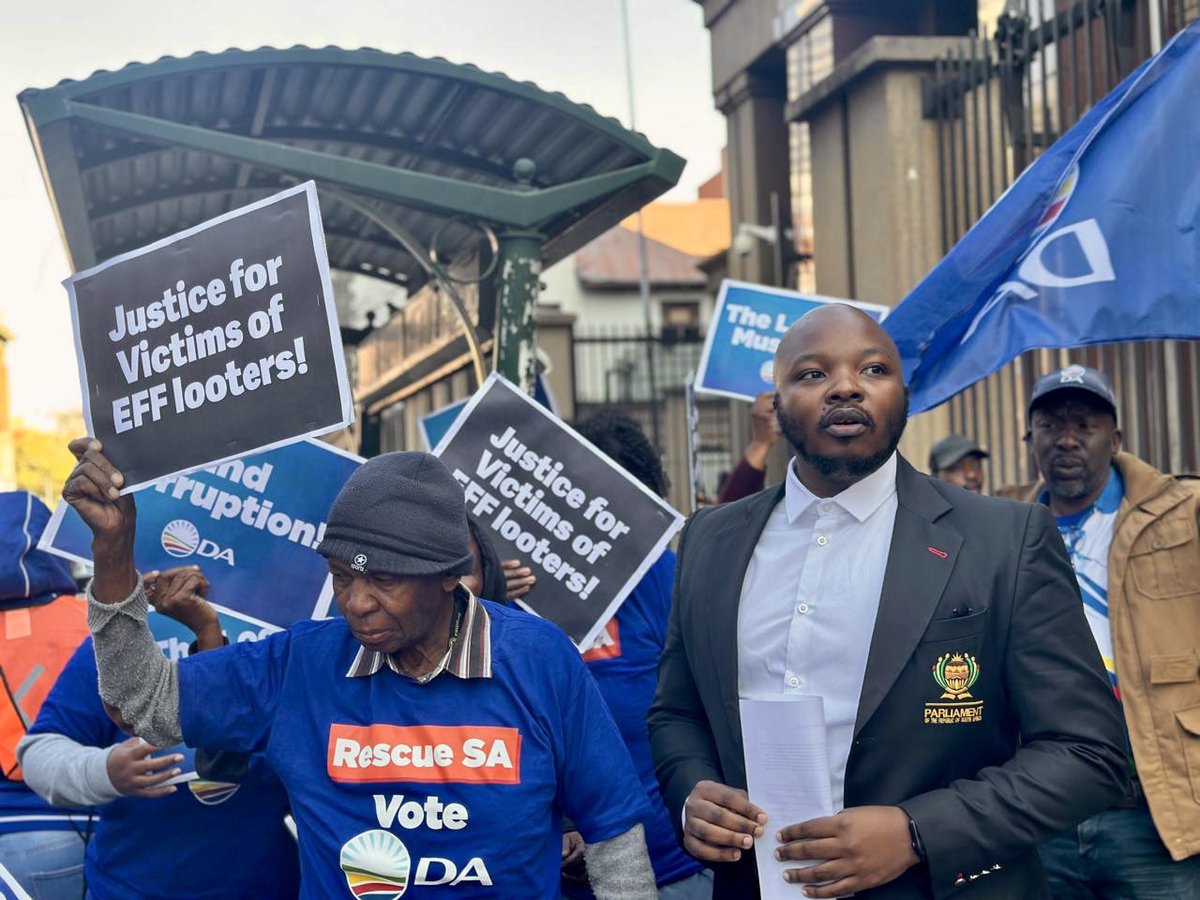 Our_DA's tweet photo. 🚨Justice for victims of EFF looters! Today, the DA is outside the North Gauteng High Court to protest against the VBS scandal perpetrators. These corrupt politicians have stolen pensioners' savings &amp; municipal funds to fund their lavish lifestyles. The DA demands accountability! https://t.co/NVltKerwrU