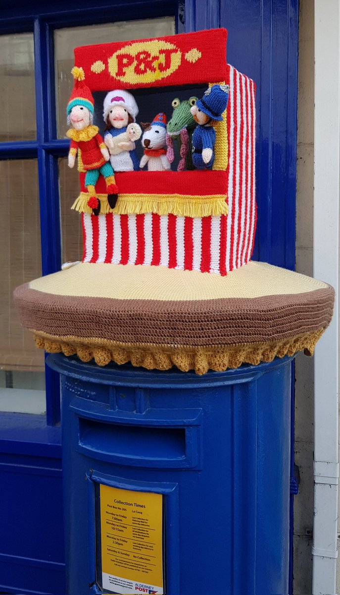 huffintpuffin's tweet photo. An excellent pillar box topper for Alderney Week!

Punch, Judy and their stage companions appear inside a red and white booth, with P&amp;J on it - not to be confused with PJ's Pantry up the street (their chips are excellent too!) #LoveAlderney https://t.co/MAuB9qQfxs