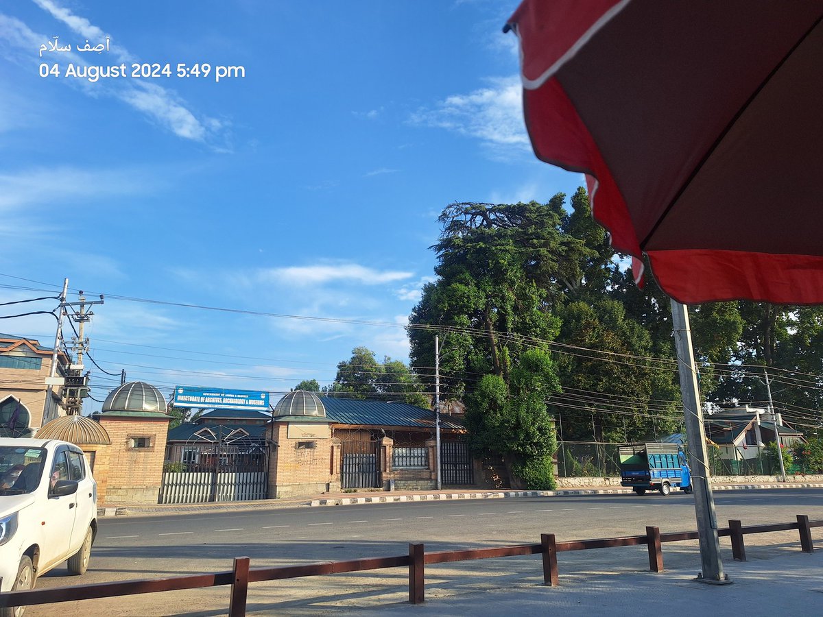 On a serene August evening, the Department of Archives, Archaeology, and Museum stands quietly under a vibrant blue sky.The sun casts a warm glow, enhancing the tranquility of the moment.