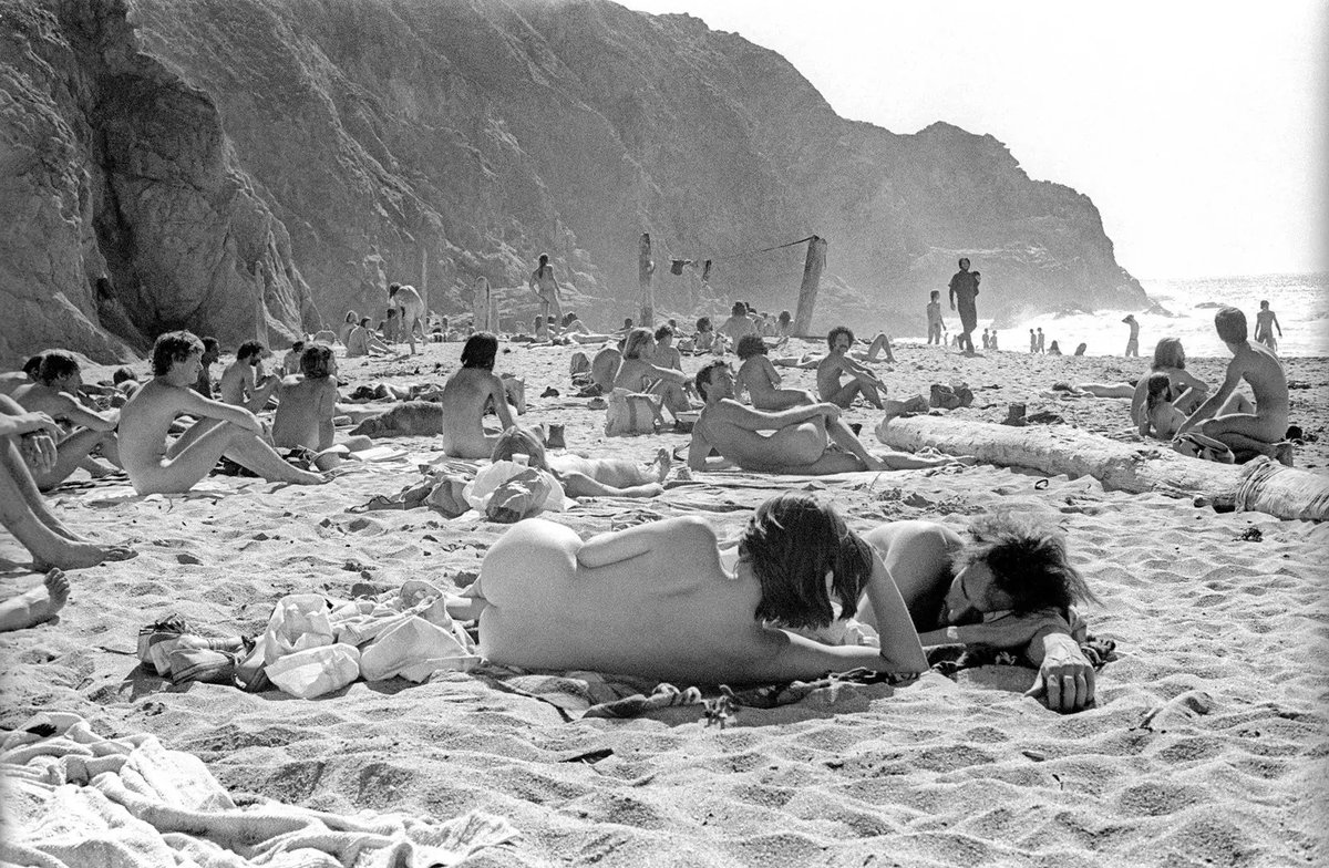 karimanesr's tweet photo. Al pasear por una playa en 1970, se observa:

- Ausencia de una epidemia de obesidad.
- La gente no se aplica cremas tóxicas cada cinco minutos.
- No existen tumbonas; descansar sobre la arena reduce el estrés y la inflamación.
- No se ven sombrillas; se toma el sol con prudencia para mejorar la salud.
- La gente no usa gafas de sol; la luz natural es beneficiosa para el organismo, incluidos los ojos, siempre con prudencia.
- No se distraen con móviles, permitiendo disfrutar plenamente de la experiencia y las conexiones personales.
- El cielo está libre de estelas de aviones; ¿había menos vuelos comerciales?