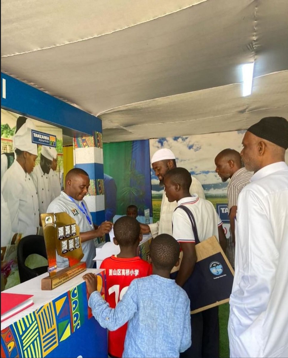 NCTTanzania's tweet photo. Bw. James Msimbe kutoka Chuo cha Taifa cha Utalii akiwahudumia wageni ambao wametembelea katika Banda la Wizara ya Mali Asili na Utalii katika maonesho ya Nanenane Jijini Dodoma https://t.co/MqIecsO63f