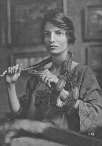 TheAttagirls's tweet photo. Woman of the Day Joan Beauchamp Procter born OTD 1897 in London, the first woman Curator of Reptiles at London Zoo, an expert at handling large pythons and crocodiles, and co-designer of the world’s first building for keeping reptiles. About half of the world’s population is thought to fear snakes. If you are one, Joan’s ideal pet would be your worst nightmare.

Her interest in reptiles and amphibians began early. As a ten year old, she kept several snakes and lizards as pets. Her favourite, a Dalmatian lizard, perched on the table next to her at mealtimes. At 16, she caused conniptions in a maths lesson by bringing a young crocodile to school.

Joan suffered lifelong chronic intestinal illness from childhood and the impact on her education meant giving up on her plans to go to Cambridge University. Instead, she started corresponding with George Boulenger, keeper of reptiles and fishes at what is now the Natural History Museum in London. Aged 19, she became his unpaid assistant and the same year, she presented her first scientific paper to the Zoological Society of London. The Society was so impressed that they asked her to help design their aquarium and the following year, in 1917, Joan was elected as a Fellow.

When Boulenger retired in 1920, Joan was entrusted with sole charge of the reptiles at the museum and initially received a small stipend until 1923 when she was hired as London Zoo’s curator of reptiles.

She didn’t hang about. Using her knowledge of reptiles, Joan helped to design the Reptile House which opened in 1927. Her ideas were revolutionary: different heat zones in the various enclosures, dimmed lights in some to reduce stress in their inhabitants, special glass that didn’t filter out UVB so the reptiles could synthesize vitamin D.

By this time, her own collection of pets had expanded beyond the reptiles and snakes in glass enclosures in her drawing room and included a pet chimpanzee, Johnnie. Nothing fazed her. At Whipsnade Zoo, she captured a brown bear that had escaped its enclosure, by enticing it with honey and shutting it in a lavatory.

Joan’s patient handling of reptiles, carefully and slowly, was quite deliberate. She believed that they could be socialised so that when they required veterinary treatment, they’d be more receptive. Her approach paid off. She was able to identify many previously unstudied diseases. Even very large and dangerous creatures seemed to trust her. One was a Komodo dragon named Sumbawa.

Sumbawa, one of the first two Komodo dragons to be imported into Europe, arrived at London Zoo in 1928 with a troublesome mouth infection. This presented something of a challenge to the Zoo’s vets. Komodo dragons have triangular, carved teeth with a serrated edge similar to a steak knife. In fact, their teeth are coated in iron and perfectly adapted to cutting their prey into ribbons. No one messes with a Komodo’s mouth with impunity.

Joan would take Sumbawa around the Zoo on a leash (she steered him by touching his tail) and because she was his primary carer - she fed him pigeons, chickens and eggs by hand while she stroked him - he accepted antibiotics and allowed her to open his mouth while she used special equipment of her own design to carry out a range of veterinary procedures, many of which hadn't been attempted before.

"They could no doubt kill one if they wished, or give a terrible bite [but they are] “as tame as dogs and even seem to show affection.”

In 1931, Joan was awarded an honorary doctorate by the University of Chicago in recognition of her achievements, making her Doctor Procter.

Joan’s recurring poor health - she had several operations and offered her resignation but the Zoo refused to accept it - meant that in time, she had to use an electric wheelchair to get around the grounds of London Zoo. She was often accompanied by Sumbawa on his leash.

Joan died from cancer in 1931, aged 34.