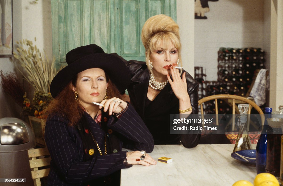 Portrait of actresses Jennifer Saunders and Joanna Lumley smoking cigarettes  on the set of the television sitcom 'Absolutely Fabulous' (1993)