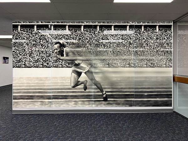 Bendheim's new glass mural captures a historic Olympic moment from runner Jesse Owens, installed with TurnKey Fusion. The image of Owens is the first thing people see when entering the headquarters of the architectural glass manufacturer. bit.ly/3SyzFud

<a href="/BendheimGlass/">Bendheim</a>