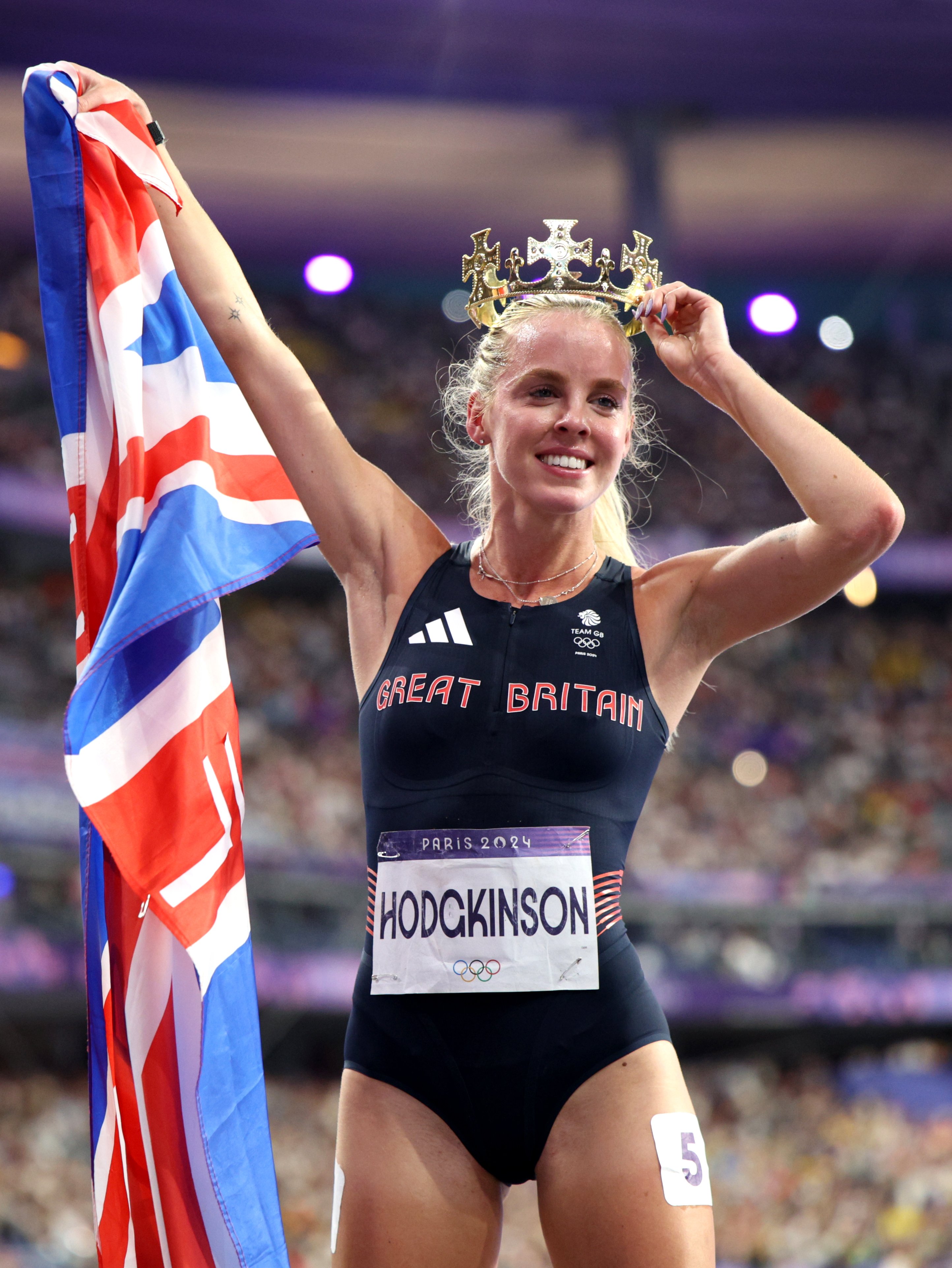 Keely Hodgkinson poses with a Union Jack and a crown after winning the 800m title at the 2024 Olympic Games in Paris.