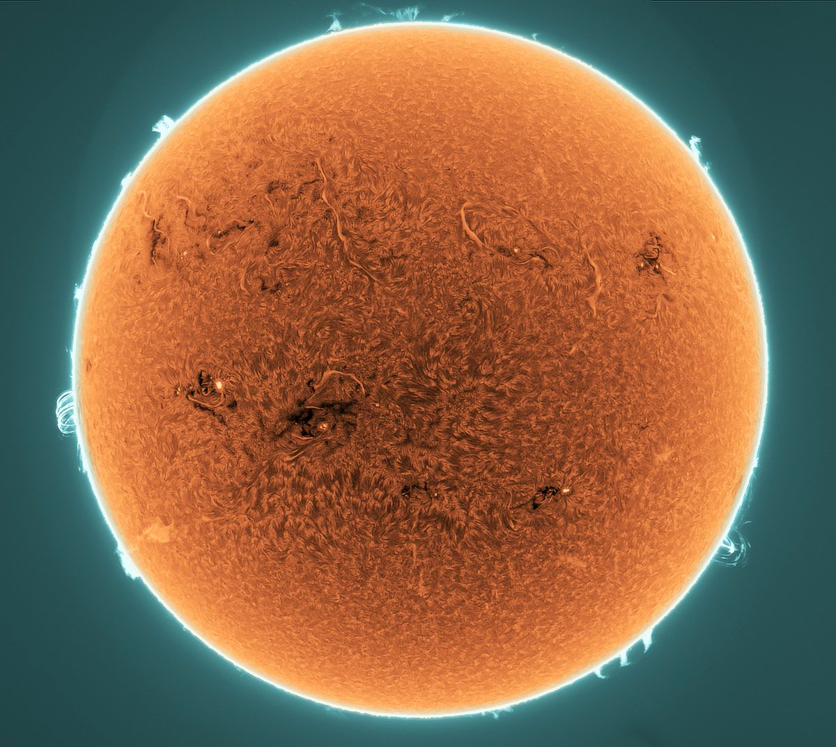 alex_riveiro's tweet photo. Esta espectacular imagen del Sol muestra el brillo de los átomos de hidrógeno en su cromosfera, el pasado 15 de mayo. Las regiones oscuras son manchas solares (y se llaman regiones activas). Además, podemos observar multitud de filamentos. Crédito:  S. Søndergaard #FelizMartes https://t.co/O4EYBchlY2