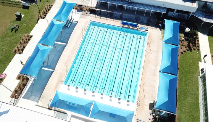 ProPlaygrounds's tweet image. This project features multiple cantilever shade structures covering the bleachers at Maclay School’s pool. These shades are designed to shield spectators and swimmers from the sun, providing comfort and protection during swim meets and other events.