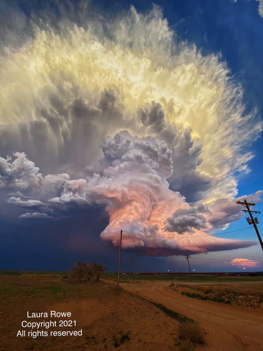 What makes this storm cloud so colorful? First, the cloud itself is composed of millions of tiny droplets of water and ice. Its bottom is almost completely flat -- but this isn't unusual. Bottom flatness in clouds is generally caused by air temperature dropping as you go up, and