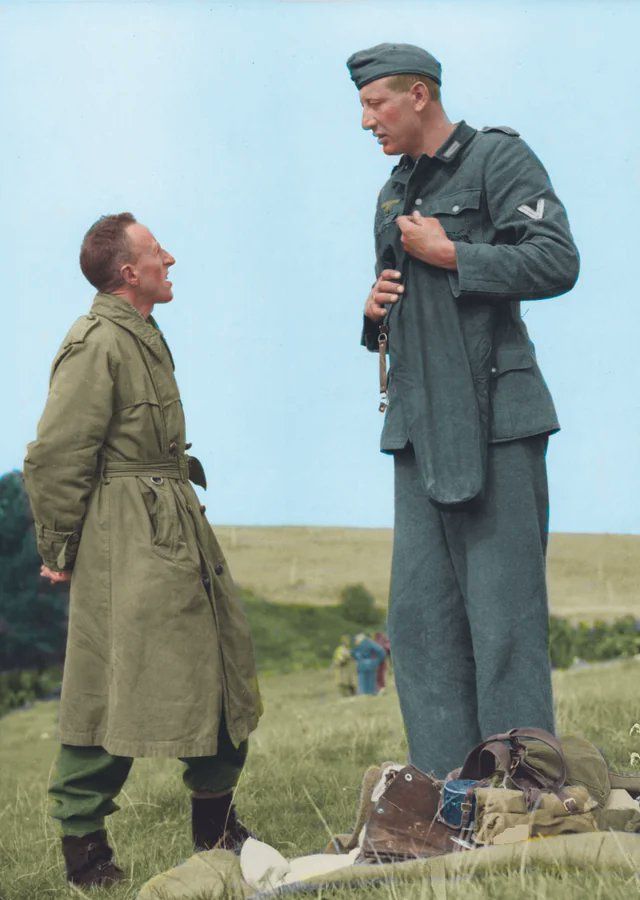 fasc1nate's tweet photo. 7'3'' (221cm) Jakob Nacken, an extremely tall Nazi soldier, chatting with 5'3'' (160 cm) Canadian corporal Bob Roberts after surrendering to him near Calais, France in September of 1944 (colorized by PeJae on Reddit). https://t.co/76izecn1Ph