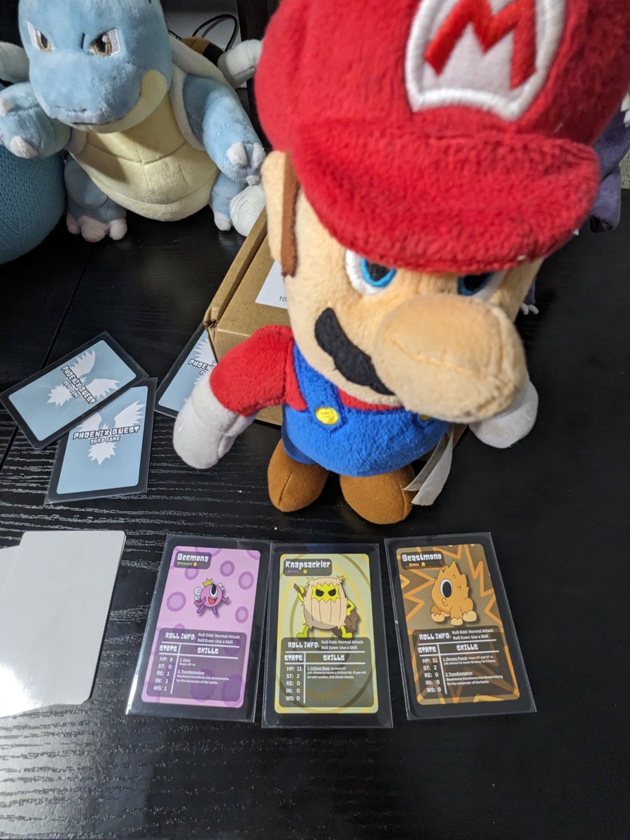 phoenixquestcg's tweet photo. Mario's favorite Phoenix Quest Card Game Party so far!
He's got a Beemona he named Princess Peach. 👑 🍑 
A Knapsackler Card which reminds him of being a Plumber... Although he's holding a Club... Not a Hammer. 🔨 🪠 
And a Beastmono Card which he named Donkey Kong! 🦍 Haaa https://t.co/0w7PspK0yJ