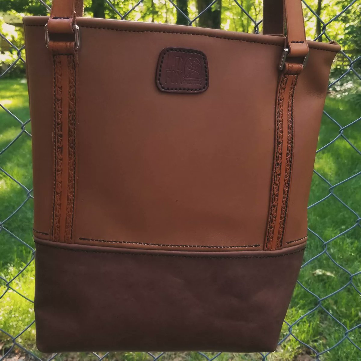 lazyfoxcreates's tweet photo. A tote I made for a secret santa exchange a few years ago. LOTS of things could have been better, but I thought it was cute and for a first try I was pleased! #tote #leatherbag #artisan #bag #purse #leather #animal #handmade #handsewn #handcrafted #gift https://t.co/yvn9QAXLZ1