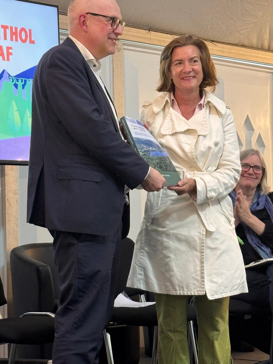 Dr Simon Brooks, Cadeirydd y Comisiwn Cymunedau Cymraeg yn cyflwyno adroddiad terfynol y Comisiwn i <a href="/Prifweinidog/">Eluned Morgan</a> yn <a href="/Eisteddfod/">eisteddfod</a> Rhondda Cynon Taf y prynhawn yma.