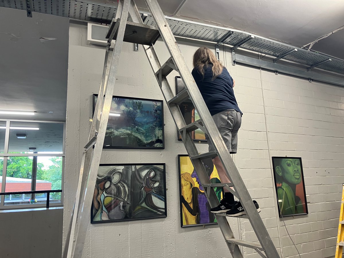 Acland_Burghley's tweet photo. Our lovely art technician Chris hanging up new student artwork in the foyer, ready for the Autumn term in September. #SummerWorking https://t.co/0I7gRZdCAV