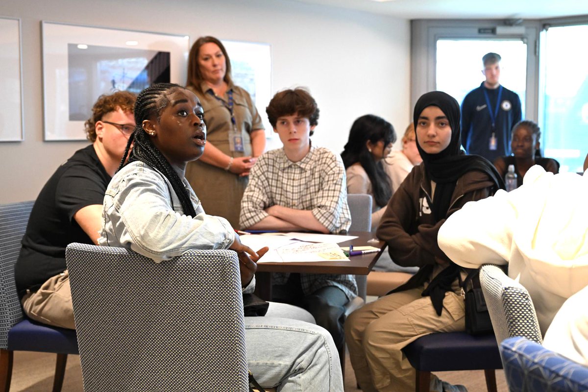 A group of guests seated, attentively listening to a speaker.