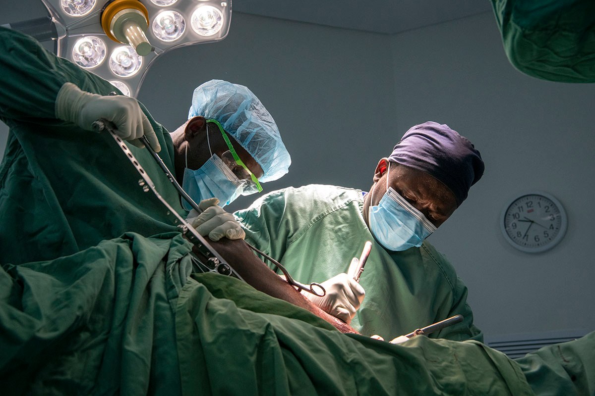 SIGNtweeter's tweet photo. SIGN Surgeons, Dr. Sylvester Nkunika, right, & Dr. Issac Kakwera place a SIGN Nail into the leg of a 27 yr-old male traffic accident victim at LION hospital in Linlongwe, #Malawi. Photo by Chuck Bigger Photography for SIGN #globalhealth #africa #SIGNsolution #SIGNimpact https://t.co/wOKiwKrtyD